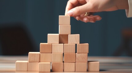 Poster - A person placing a stack of wooden blocks. Great for business and education concepts