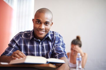 Wall Mural - Classroom, university student and black man with smile, portrait and reading textbook for studying. Male person, happy and learning for information with research for education with scholarship