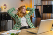 © Andrii Iemelianenko - Happy relaxed businesswoman sitting at home office desk works on laptop and stretching arms after finishing work. Girl freelancer working online, remote job. E-learning, browsing internet on netbook