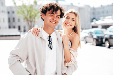 Portrait of young smiling beautiful woman and her handsome boyfriend in casual summer clothes. Happy cheerful family. Female having fun. Couple posing in the street background at sunny day