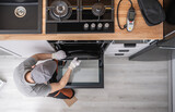 Fototapeta Zachód słońca - Professional Appliances Installer and Testing New Kitchen Stove