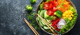 Fototapeta Lawenda - A bowl filled with a variety of colorful vegetables such as carrots, bell peppers, and mushrooms, is accompanied by a pair of chopsticks placed next to a fresh broccoli floret.