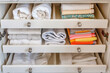 Organized towels in a neat drawer - A detailed image of an open drawer neatly filled with carefully folded towels of various colors, representing organization and cleanliness