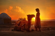 Silhouette of woman in traditional national clothes looks at beautiful sunset in desert next to yurt and camel.