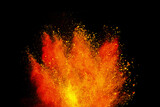 Fototapeta Tęcza - Abstract powder splatted background. Colorful powder explosion on black background. Colored cloud. Colorful dust explode. Freeze motion of orange color powder exploding 
