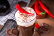 © ricka_kinamoto - Hot spicy coffee latte with chili pepper, whipped cream and chocolate chips on top, copy space