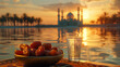 dates in a bowl and a glass of water in table with a mosque in the distance. ramadan kareem holiday celebration concept