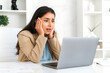 © Kateryna - Stress, worried. Puzzled indian or arabian business woman, sitting at a work desk in the office, confused looks at laptop screen, perplexed by the information received, nervous