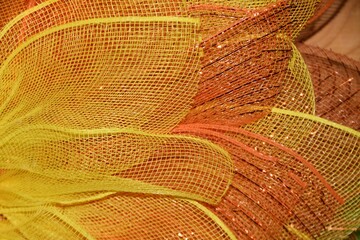 background of orange and yellow mesh material leaf on wreath