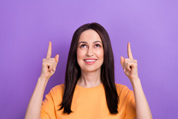 Wall Mural - Portrait of optimistic girl wear oversize t-shirt look directing up at interesting offer empty space isolated on violet color background