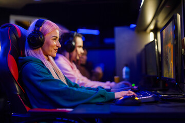 Young woman with pink hair playing video game on a Gaming convention