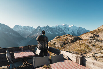 Wall Mural - Male backpacker enjoying the view Mont Blanc massif on balcony in French Alps at France