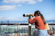 Tourist woman look at the binocular in the city