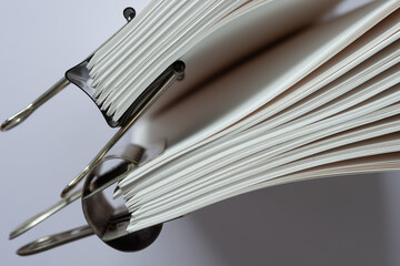 Canvas Print - close-up of paper signatures (bookbinding) held together with spring clips arranged standing