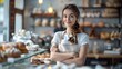 © kiatipol - Friendly Bakery Girl Smiling in Front of Pastries