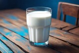Fototapeta Uliczki - Glass of milk on wooden table.
