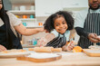 © chokniti - happy child family with father or mother cooking fun together for bakery bread meal in kitchen, young African little kid daughter girl and parent in love childhood lifestyle at home for food homemade
