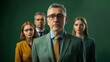 Une équipe de collaborateurs derrière leur manager, un homme respectable costumé en vert et portant des lunettes