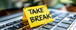© Bartek - Yellow sticky note with TAKE A BREAK handwritten message on a laptop keyboard, a reminder for work-life balance, rest, and self-care during busy workdays