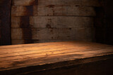 Fototapeta Tulipany - Old wood table with blurred concrete block wall in dark room background. High quality photo
