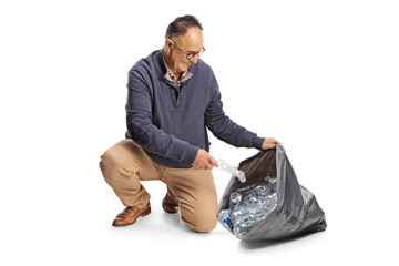 Poster - Mature man collecting plastic bottles in a black garbage bag