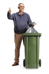 Poster - Smiling mature man throwing a waste bag in a dustbin and gesturing thumbs up