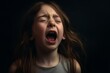 Cute little child crying on dark background. ?lose-up portrait of a screaming baby. Child shouting loud. Portrait of shocked, angry, emotional little girl screaming and crying against black background