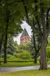 Konstantino-Eleninskaya Tower of the Moscow Kremlin behind trees and lawn. Summer landscape in Kremlin garden.