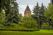 Konstantino-Eleninskaya Tower of the Moscow Kremlin behind trees and lawn. Summer landscape in Kremlin garden.