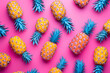 Colorful fruit pattern of fresh yellow pineapples on a pink background. Flat layout, top view.