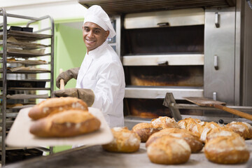 Wall Mural - Baker pulls hot bread out of the oven