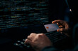 © Summit Art Creations - Cropped hands image in criminal anonymous male approaching credit card of personal information database for codding encryption scam program in privacy system at night at blue neon light room. Surmise.