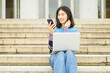 © luisrojasstock - young man sitting on a staircase with a laptop computer and a mobile phone