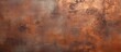 A weathered metal wall with rusted patches contrasts against a brown background, showcasing the textural decay and aged appearance of the surface.
