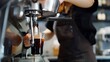 © Generative AI - Professional female barista in black uniform making drip coffee Person pouring fresh aromatic coffee from glass flask in cup hands close up Alternative coffee brewing : Generative AI