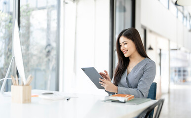 Wall Mural - Young pretty business woman using digital tablet sitting in the office