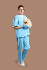 Sticker - Female veterinarian with cute Pomeranian dog on beige background