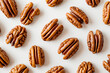 High-quality, top view image of multiple pecan nuts arranged neatly on a white background, ideal for food-related content and Thanksgiving designs with space for text