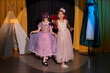 © Seventyfour - Full length portrait of two young girls wearing costumes acting on stage in theater lit by spotlight copy space