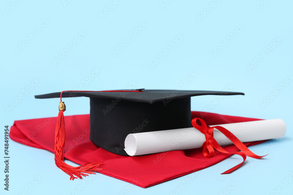 Mortar board and diploma on blue background