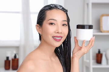 Poster - Young Asian woman with jar of hair mask in bathroom, closeup