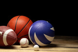 Fototapeta Mapy - Set of various sport balls on wooden floor on black background