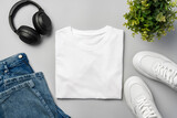 Fototapeta Mapy - T-shirt, jeans and white sneakers on gray background top view