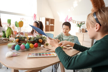 Sticker - Little children in bunny ears making Easter crafts on table at home