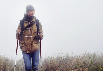 Canvas Print - Woman, hiking and nature with trekking sticks, winter and support for fog trail in mountain. Athlete, backpack and mountaineering gear for safety in wet environment, slippery and walking for fitness