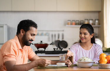 Joyful couples enjoying breakfast together at home on dining table - concept of healthy eating, family bonding and relaxation