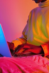 Aufkleber - A man sitting on a bed and using a laptop computer. Suitable for technology and work from home concepts
