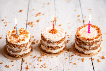 Wall Mural - Small cakes with candles on white background