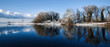 Winterliche Uferlandschaft mit Bäumen und Büsche, Reflektion im Wasser Blauer Himmel. Hintergrund, Wallpaper