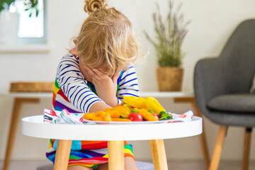 Wall Mural - Child eats vegetables at home. Selective focus.